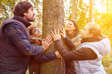 Familie berührt Baum mit Händen als Naturreligion Konzept