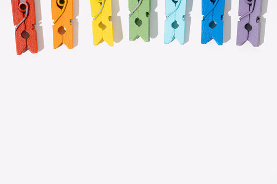 row of isolated rainbow clothespins. Background with text space banner. Minimalistic pride flag of freedom and tolerance