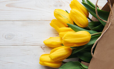 Bouquet of yellow tulips in a kraft paper bag
