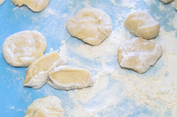 Fototapeta na wymiar pieces of dough in flour on a blue background