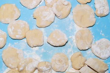 pieces of dough in flour on a blue background