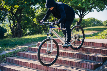 Woman free rider riding bike going down city stairs