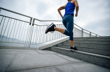 Healthy lifestyle fitness sports woman runner running up stairs on seaside trail