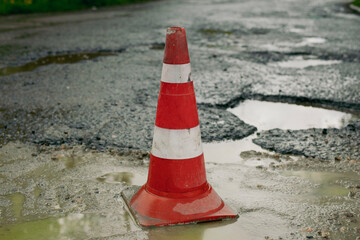 Warning about hole in road. Signal cap on asphalt. Triangle of orange light.