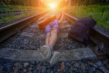 Male person lying on rail track and play acoustic guitar at summer day. Freedom and lifestyle...