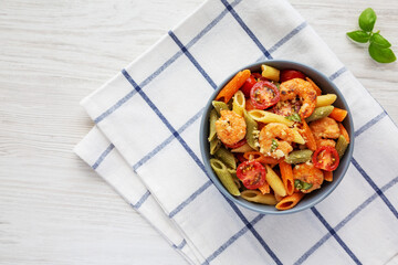 Homemade Tri-Color Penne Salad with Shrimp, Tomato and Basil Bread Crumbs in a Bowl, top view. Flat lay, overhead, from above. Space for text.