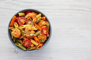 Homemade Tri-Color Penne Salad with Shrimp, Tomato and Basil Bread Crumbs in a Bowl, top view. Flat lay, overhead, from above. Space for text.