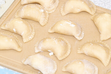 Fototapeta na wymiar dumplings with cottage cheese on the kitchen board