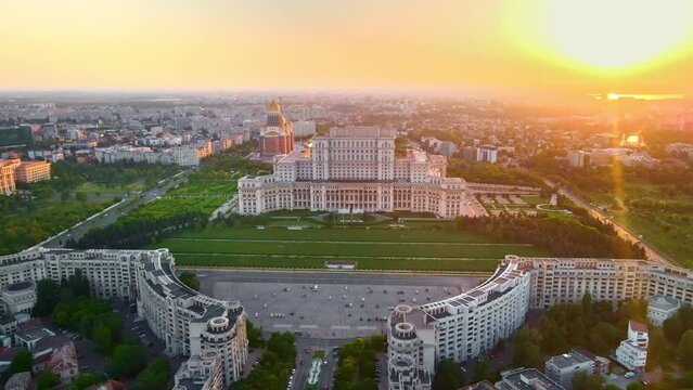 Aerial drone view of Palace of the Parliament in Bucharest downtown at sunset, Romania. Multiple districts around