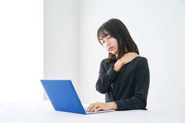 肩が凝るデスクワークのビジネスウーマン