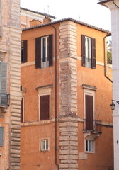 Fototapeta na wymiar Traditional Orange Brown Building Facade Detail with Windows and Street Sign in Rome, Italy