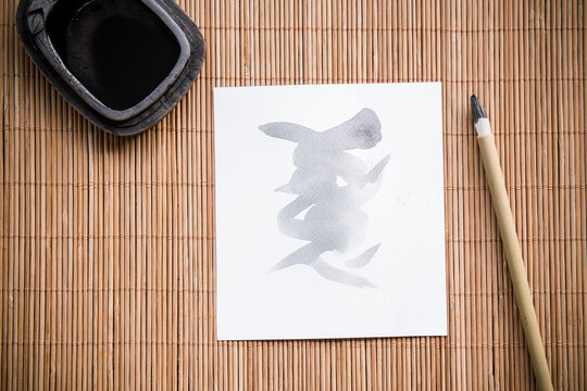 calligraphy brush with white paper and and inkstone on bamboo   mat. picture for add text or greeting card chinese new year. Chinese traditional painting text