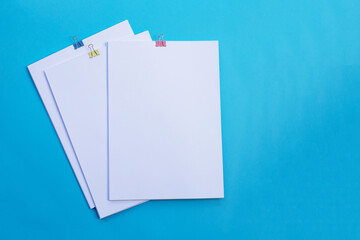 white paper with clip on blue background.