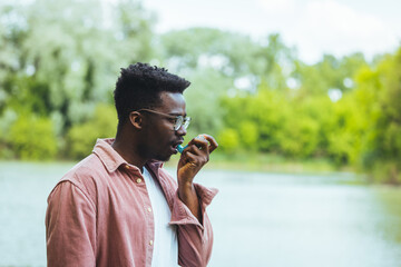 Men who use an inhaler for outdoor asthma. An African with breathing problems uses a smoke inhaler...