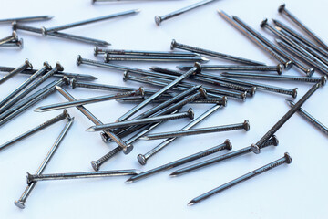 Silver steel nails on white background.
