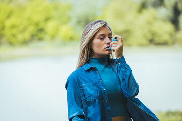  Young girl using asthma inhaler to prevent an asthma attack. Pharmaceutical product to prevent and treat asthma.