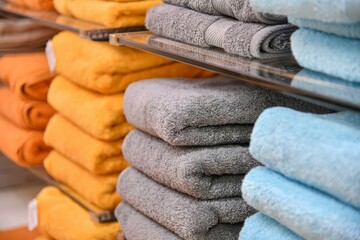 Shower towels of different colors are stacked on the counter of the store.