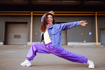 Street dancer in stylish clothes dancing and showing some moves. Sport, dancing and urban culture...