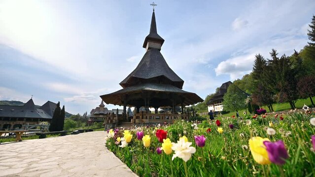 View of the Barsana Monastery, Romania. Inner court with gazebo and others buildings, greenery and flowers, forest around it