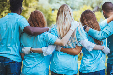 Rear view of a group of unified volunteers who are participating during a community cleanup day.