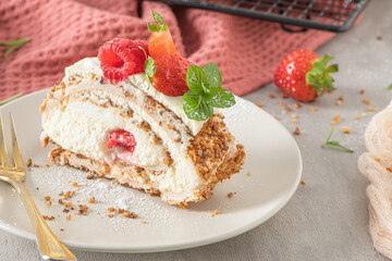 Meringue roll with a gentle airy cream, crunchy peanut, mint, rosemary and filling with raspberries and strawberries. Pavlova summer sweet dessert