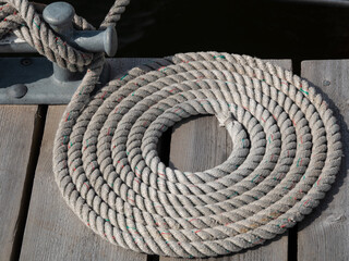 aufgerolltes Seil eines Segelbootes an einem Anleger