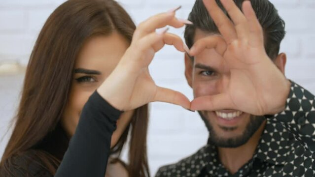 Caucasian-Cuban couple making heart shape with their fingers. Togetherness and love concept. High quality 4k footage
