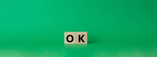 Ok symbol. Concept word Ok on wooden cubes. Beautiful green background. Business and Ok concept. Copy space.