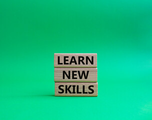 Learn new skills symbol. Concept words 'Learn new skills' on wooden blocks. Beautiful green background. Business and Learn new skills concept. Copy space.