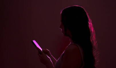 Unrecognizable woman in neon purple light scrolling social media in mockup smartphone gadget. Futuristic metaverse.