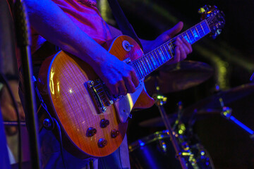 Naklejka premium The guitarist plays on guitar. Hands of a Guitar player playing the guitar. Selective focus. Soft focus