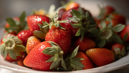 Strawberries on a plate. First summer harvest of strawberries. Fresh ripe strawberries background.