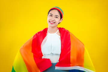 Happy asian woman with pride flag rainbow isolated yellow background. lgbtq and lgbtq+ concept