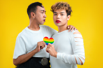 asian gay couple with pride flag rainbow paper heart color background. lgbtq and lgbtq+ concept