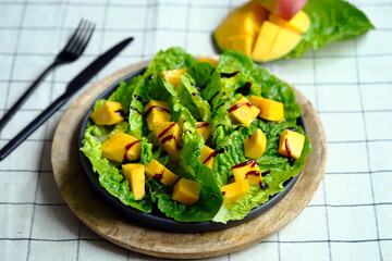 Healthy bright salad with mango and green romaine leaves. Diet food.