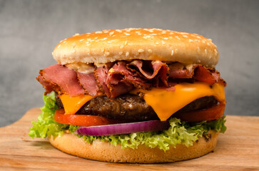 Homemade cheeseburger with cheese, lettuce, onion and tomatoes