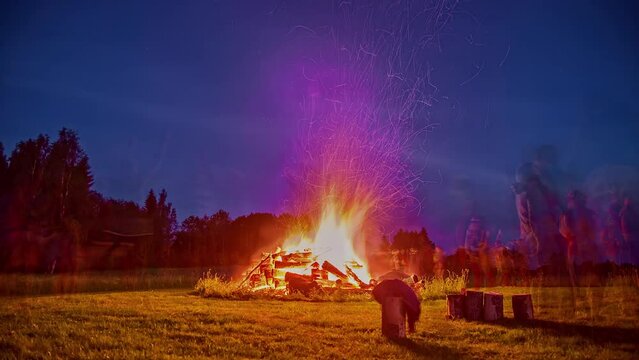 Midsummer Celebration With Bonfire And Many People Relaxing And Dancing.