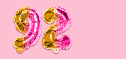 Rainbow foil balloon number, digit ninety two on a pink background. Birthday greeting card with inscription 92. Top view. Numerical digit. Celebration event, template. Banner