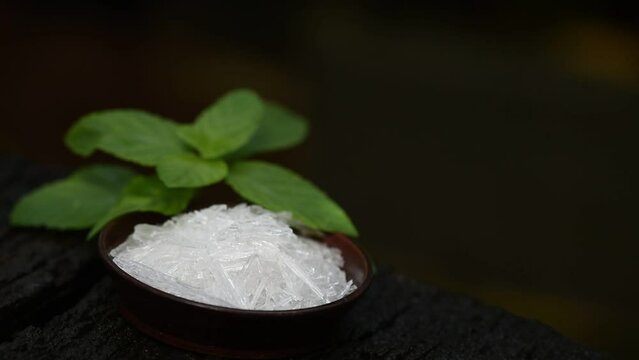 Menthol crystal and peppermint leaves on nature background.