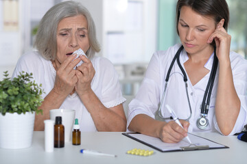 Senior woman portrait in hospital with caring doctor