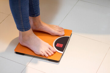 Closeup photo of a Woman standing on a digital weight scale