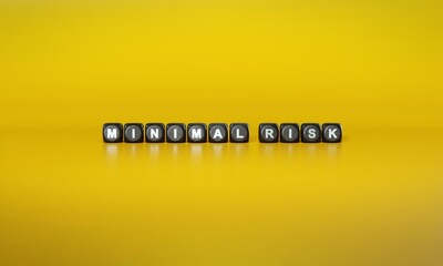 Words ‘Minimal risk’ spelled out in white text on dark wooden blocks against plain yellow background. 3D rendering