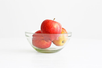 Apples in a glass bowl on white background