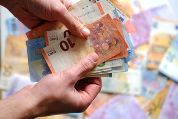 close-up of female hands count paper 10 euro banknotes of the european union, paper banknotes on...