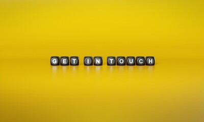 Words ‘Get in touch’ spelled out in white text on dark wooden blocks against plain yellow background. 3D rendering