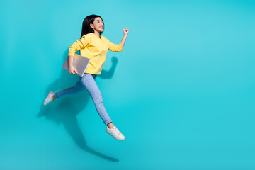 Fototapeta na wymiar Full length photo of shiny sweet woman wear yellow pullover jumping holding device empty space isolated teal color background