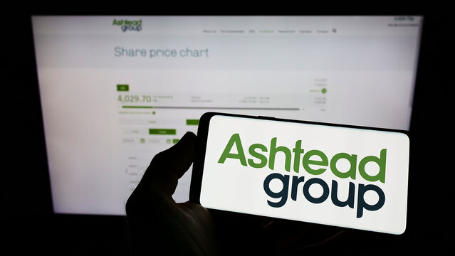 Stuttgart, Germany - 05-29-2022: Person holding mobile phone with logo of equipment rental company Ashtead Group plc on screen in front of web page. Focus on phone display.