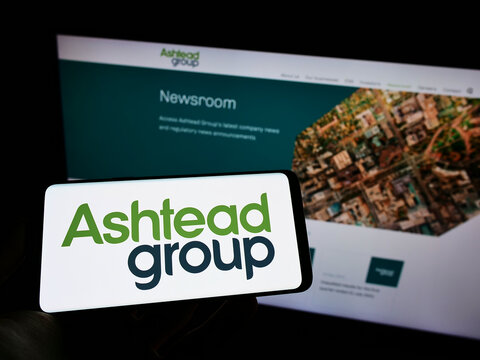 Stuttgart, Germany - 05-29-2022: Person holding cellphone with logo of equipment rental company Ashtead Group plc on screen in front of business webpage. Focus on phone display.