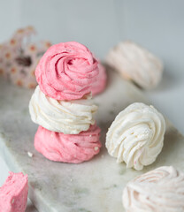 Soft marshmallows pink and white on a marble stand. Close-up, Vertical