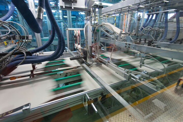 Close up detail of cartographic industrial machinery at work in a production line, conveyor belts...